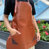 A genuine leather apron by GRIF, featuring a full-length design with adjustable straps and a stylish brown finish